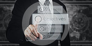 Businessman Pressing Button, Icons on Virtual Screen. Objectives, Business, Planning