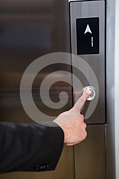 Businessman pressing elevator button