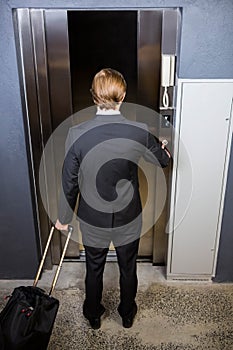 Businessman pressing elevator button