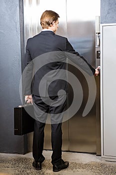 Businessman pressing elevator button