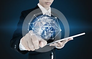 Businessman pressing on global network connection and data, on blue background. Elements of this image are furnished by NASA