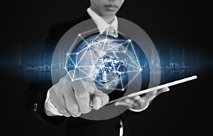 Businessman pressing on global network connection and data, on blue background. Elements of this image are furnished by NASA