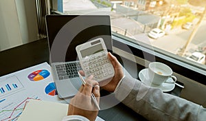 A businessman pressing his finger on a calculator to calculate expenses Finance is calculating tax information. and analyze financ