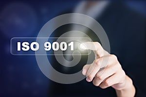 Businessman pressing a ISO 9001 concept button.