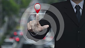 Businessman pressing map pin point location button over blur of rush hour with cars and road in city, Map pointer navigation onlin