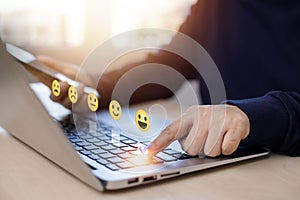 Businessman pressing smile on laptop keyboard customer service, evaluation concept