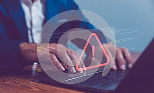 Businessman or programmer using laptop with triangle caution warning sign, coding, cryptography, hacker, crime, virus, for