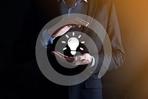 Businessman with protective gesture standing posture hand holding bulb icon ideas of new ideas with innovative technology and