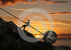 Businessman Pull Uphill A Big Rock With Chain In Front Of Sunset
