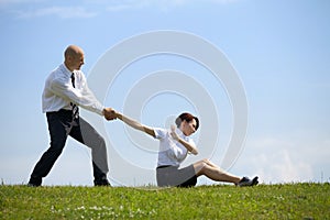 Businessman pulling businesswoman's hand in park