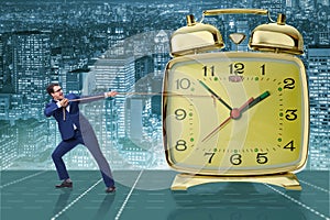 The businessman pulling clock in time management concept