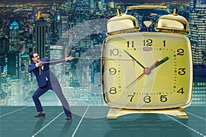 The businessman pulling clock in time management concept