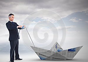 Businessman pulling paper boat