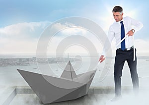 Businessman pulling paper boat with rope in city sky