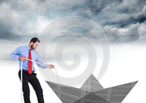 Businessman pulling paper boat with rope in sky