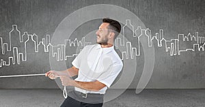 Businessman pulling rope in room with city drawings