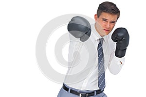 Businessman punching with black boxing gloves