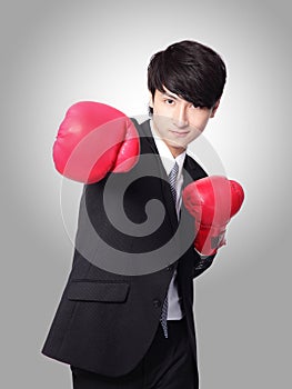 Businessman punching and hitting with boxing gloves