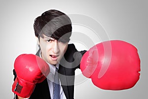 Businessman punching and hitting with boxing gloves