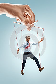 Businessman puppet on gray background