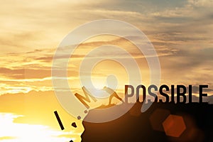 Businessman push impossible wording to possible wording on top of mountain with sunlight. Positive mindset concept photo