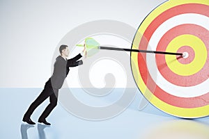 Businessman pushes arrow exactly in bull's-eye concept