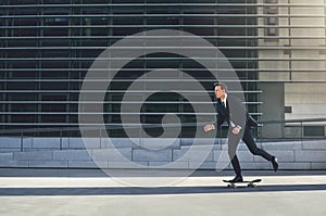 Businessman pushing his skateboard with purpose