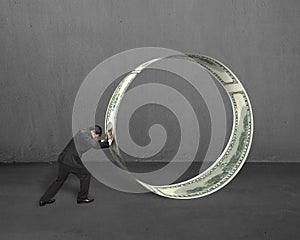 Businessman pushing money circle in concrete background