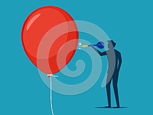 Businessman pushing a needle to poke a balloon. business risk concept or dangerous situation