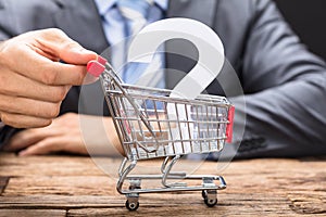 Businessman Pushing Question Mark In Shopping Cart