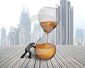 Businessman pushing tilt hourglass