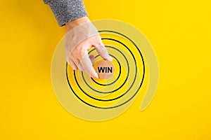 Businessman put round block with Win word aim at concentric circles of marketing target