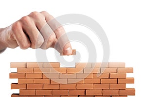 Businessman puts a brick to build a wall. Concept of new business, partnership, integration and startup