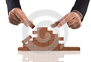 Businessman puts a brick to build a wall. Concept of new business, partnership, integration and startup