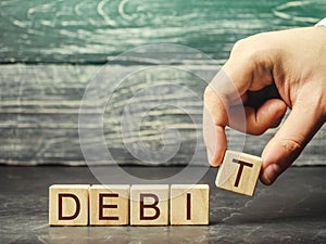 Businessman puts wooden blocks with the word Debit. Fundraising, company profit. Debit account. Business and finance concept.