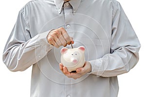 Businessman putting coin into the piggy bank