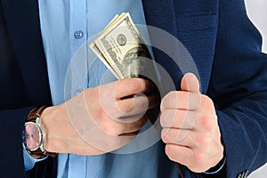 Businessman putting money in his suit pocket - closeup shot