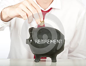 Businessman putting money on a piggy bank