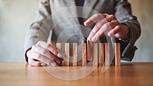 Businessman putting wooden block in a row on the table for business concept