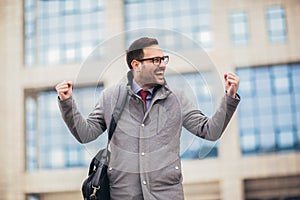 Businessman raising his arms outdoors - happy, success