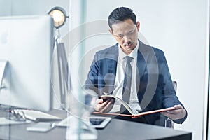 Businessman reading book in office