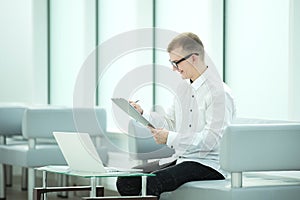 Businessman reading business document in office lobby