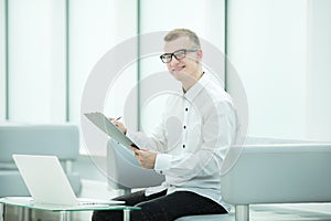 Businessman reading business document in office lobby