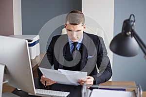 Businessman reading contract in office