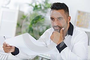 businessman reading contract papers in office