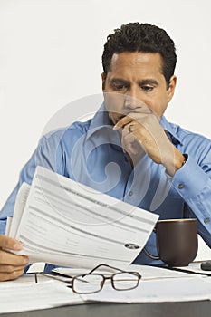 Businessman Reading Document In Office