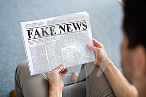 Businessman Reading Fake News Article On Newspaper