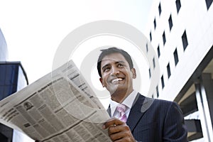 Businessman Reading Newspaper Outdoors