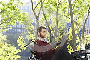 Businessman Reading Newspaper In Park