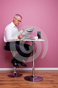 Businessman reading a newspaper sat in a cafe